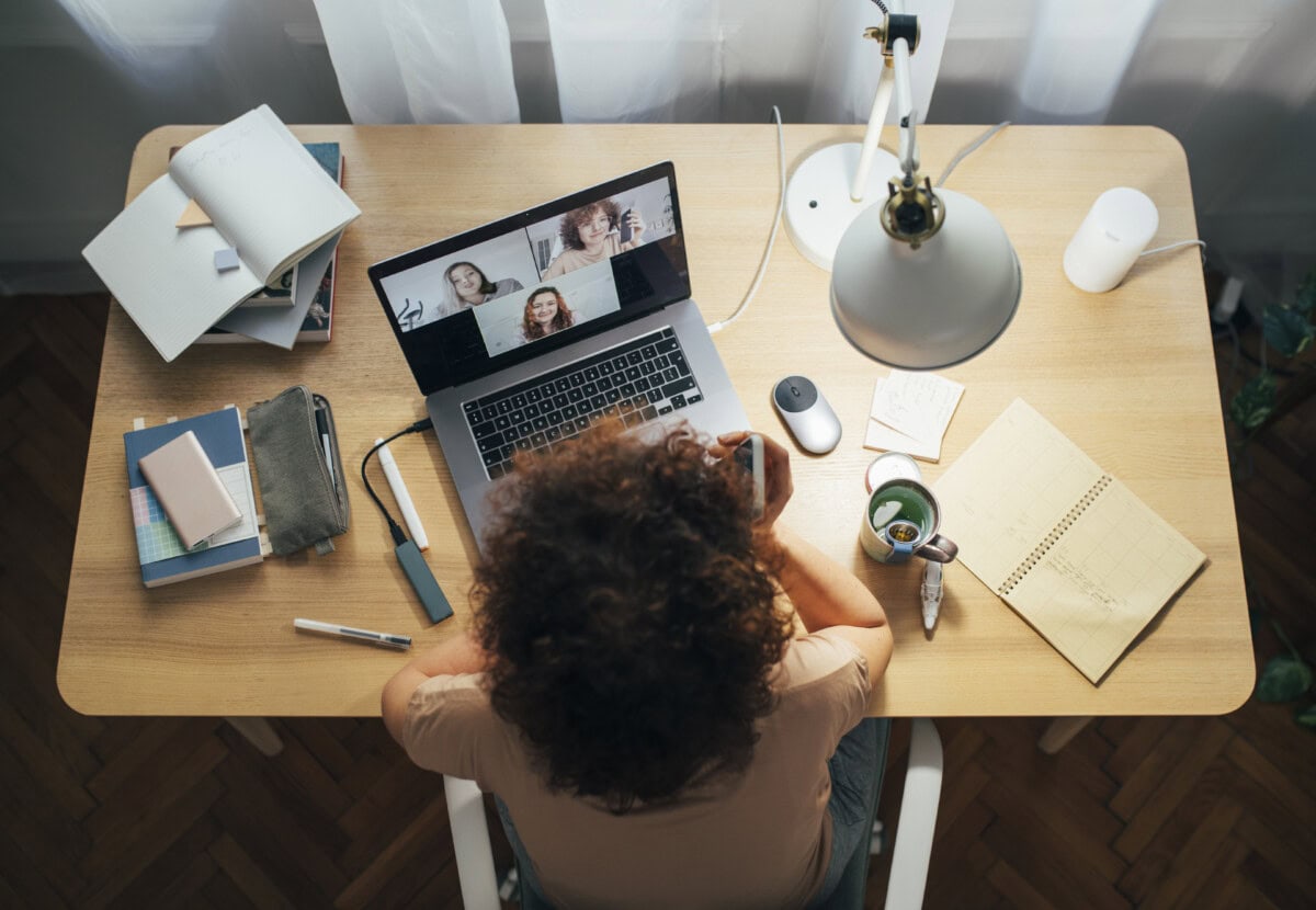 social distancing and self care: happy woman teleconferencing from home